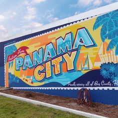 a mural on the side of a building that says panama city, and features an image of a palm tree