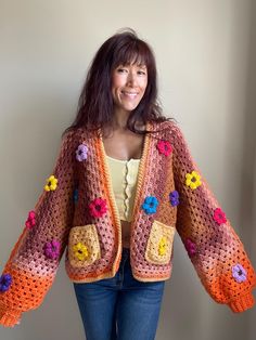 Channel the vibrant spirit of the '70s with this handmade, oversized cardigan! Bursting with personality, this unique piece is adorned with chunky, colorful mini flowers that add a playful pop of color. The open-front design and relaxed, oversized fit make it effortlessly stylish and comfortable, while the ribbed sleeves provide a cozy touch. With functional pockets on the front, it's as practical as it is eye-catching. Crafted from 100% acrylic yarn, this lightweight cardigan is perfect for layering and easy to care for--just machine wash cold and tumble dry. Sized for US women small to medium, it's the perfect blend of retro charm and modern comfort. Size : Small to Medium  Machine wash cold / tumble dry Retro Flower Crochet, Crochet Flower Cardigan, Oversized Crochet Cardigan, Crocheted Tops, Retro Crochet, Boho Whimsical, Flower Cardigan, Mini Flowers, Cardigan Crochet