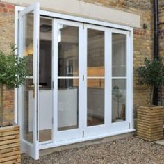 an outside view of a building with glass doors and plants on the side of it