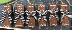 some brown gingerbreads with black and white bows are hanging on a wall next to a ruler