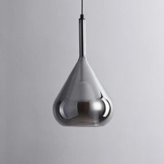 a modern light fixture hanging from a ceiling in a room with grey walls and flooring