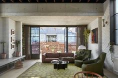 In the living room, exposed concrete has been paired with white-painted brick and a black steel fireplace. Mediterranean Culture, Architecture Jobs, Brick Cladding, Architecture Company, Passive Solar Design, Cladding Systems, Solar Design