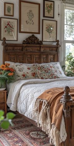 a bed sitting in the middle of a bedroom with pictures on the wall above it