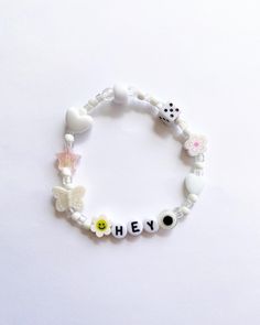 a bracelet with the word hey written in small letters on it, along with other charms