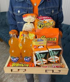 a person holding a tray with drinks and snacks