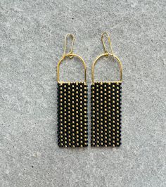 Black and Gold glass bead statement earrings inspired by a baltic basket weave motif. The beads sparkle beautifully in the light accentuating the basket weave pattern. Each bead is hand sown row after row. Glass beads reveal a beautiful shine as they catch the light. Could be worn daily or on a special occasion. Lightweight and sturdy design! Make a statement with these handmade bead earrings with a modern and bold design.  Minimalist with a pop of color to brighten up any outfit or occasion. 14K plated gold earring components. The earrings are handmade by me in my tiny studio in Minneapolis. Black Handwoven Drop Earrings, Handwoven Black Drop Earrings, Elegant Woven Dangle Earrings, Elegant Woven Drop Earrings, Elegant Woven Dangle Jewelry, Elegant Gold Woven Earrings, Black Earrings With Handwoven Round Beads, Black Handwoven Earrings With Round Beads, Elegant Woven Earrings For Party