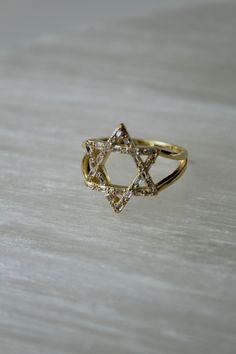 14k gold vermeil and sterling silver Star of David rings Size 5-9 available Sterling silver and 14k gold vermeil Star of David statement rings are exquisite pieces of jewelry that combine traditional symbolism with modern elegance. This ring is designed to make a bold statement, featuring intricate craftsmanship and a striking combination of precious metals. Materials and Composition 1. Sterling Silver: The base of the ring is typically made from sterling silver, which gives the ring durability Star Of David Ring, Silver Spiritual Rings With Star Of David, Celestial Diamond Star Of David Jewelry, Gold Diamond Star Of David Jewelry, Gold Star Of David Fine Jewelry, Luxury Gold Star-shaped Rings, David Ring, Jewish Star, Crystal Stars