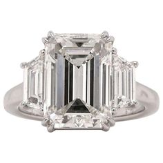 This magnificent platinum ring features a GIA certified 4 carat emerald cut diamond of exceptional quality. The diamond boasts a VVS1 clarity grade and a pristine D color grade. Polish and symmetry are rated excellent and very good, ensuring maximum brilliance and fire. Flanked by two trapezoid diamonds on either side, the ring exudes a harmonious balance of elegance and sparkle. The absence of fluorescence further enhances the purity and radiance of the central diamond. This exquisite ring is a true testament to timeless elegance and superior craftsmanship. Bling Ideas, Rare Diamond, Emerald Cut Diamond Engagement Ring, Emerald Cut Diamond Engagement, Contemporary Engagement Rings, Emerald Cut Diamond Ring, Flawless Diamond, Platinum Diamond Engagement Rings, Platinum Diamond Rings