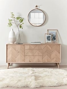 a room with a white rug and a wooden dresser