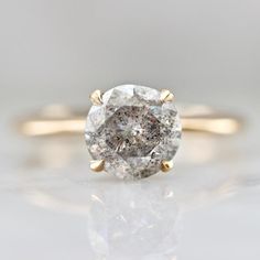 an oval diamond engagement ring with two yellow gold accents