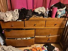 an untidy dresser with clothes on it