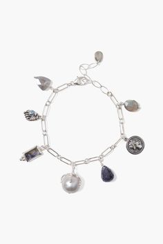 This silver charm bracelet features a glowing mix of charms including a bezel set labradorite stone, silver portrait coin, iolite, and grey moonstone drops, and a silver claw grasping a freshwater pearl. Stack with more gold bracelets for a playful layered look. Sterling silver, labradorite, grey baroque pearl, iolite, grey moonstone. 6 1/4" - 7 3/4" adjustable. Handmade in Vietnam. Charm Bracelet Silver, Nugget Bracelet, Grey Moonstone, Horseshoe Necklace, Gold Bracelets, Silver Chain Bracelet, Silver Charm Bracelet, Labradorite Stone, Pearl Grey