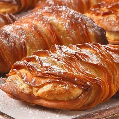 croissants with powdered sugar on them sitting on a tray