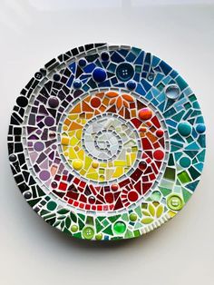 a multicolored glass plate with circles and dots on the bottom, sitting on a white surface