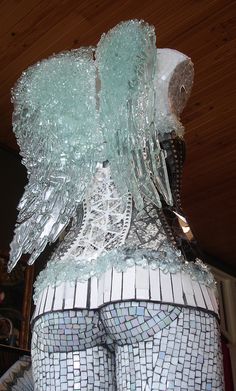 there is a statue made out of glass and silver foil with an angel on it's back