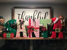 a wooden sign that says thank you all with christmas decorations and gifts on top of it