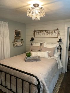 a bedroom with a bed, chandelier and pictures on the wall above it