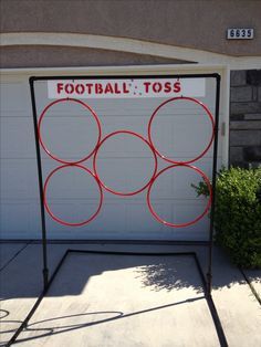 there is a sign that says football toss in front of a garage with three circles on it