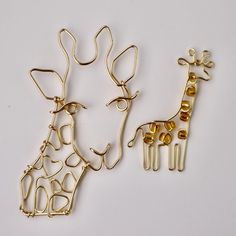 two giraffe shaped brooches sitting next to each other