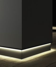 an empty room with some lights on the floor and a black wall in the background