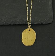 Simple gold oval necklace featuring a textured gold pendant. The edges are not entirely smooth and they have a distressed texture that make them look like relics from long ago. Charms are manufactured in the US and are made of pewter that meet CPSIA standards. Pendant is 7/8 inches tall and 3/4 inches wide (22 x 19mm). Your choice of necklace length - 16, 18 or 20 inches. Thank you for stopping by! Find more handmade necklaces here - https://www.etsy.com/shop/BeautifulByCharlene?section_id=13383312 Enter my shop here - https://www.etsy.com/shop/BeautifulByCharlene Gold Oval Brass Necklaces, Gold Oval Pendant Brass Necklace, Gold Oval Brass Necklace, Gold Brass Necklace With Oval Pendant, Gold Oval Pendant Necklace In Brass, Oval Gold Brass Necklace, Gold Necklaces With Large Oval Pendant, Gold Oval Necklace With Large Pendant, Gold Hammered Oval Pendant Necklace