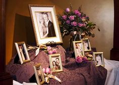 a table topped with framed pictures and flowers