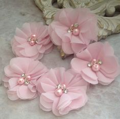 four pink flower hair clips with pearls on them