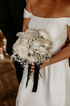 a close up of a person holding a bouquet of flowers and wearing a black tie