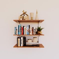 two wooden shelves with books and vases on them