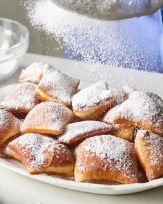 powdered sugar is sprinkled on top of pastries in a white plate