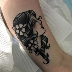 a woman's foot with a black and white tattoo design on her left leg