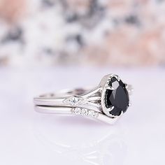 a white gold ring with an oval cut black diamond