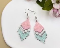 Brighten up your accessory collection with these **Pink and Aqua Woven Chevron Earrings**. These stunning earrings feature a playful and chic chevron pattern, meticulously woven with pink and aqua seed beads. Perfect for adding a pop of color to any outfit, these beaded earrings are a must-have for those who love casual elegance. Designed with a short fringe that adds just the right amount of movement, these earrings are both lightweight and comfortable, making them ideal for everyday wear. The Pink Seed Bead Earrings, Earrings Casual, Aqua Earrings, Chevron Earrings, Casual Earrings, Beading Patterns Free, Seed Beading, Beaded Jewlery, Short Fringe