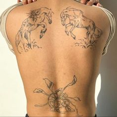 the back of a woman with tattoos on her body and two horses drawn on it