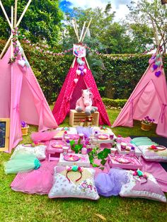 a pink teepee tent set up for a birthday party with lots of food and decorations