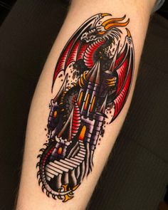 a tattoo with a dragon on it's arm and an arrow in the middle