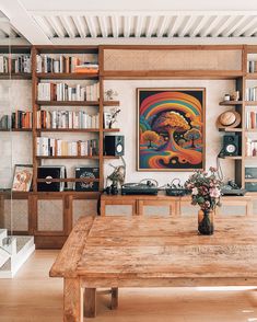 a wooden table sitting in front of a book shelf filled with books