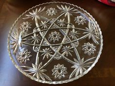 a glass plate with an intricate design on the bottom and sides, sitting on a table