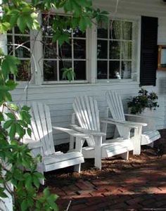 three white adiron chairs sitting on the front porch