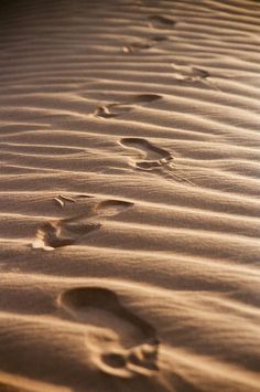 two footprints in the sand near each other