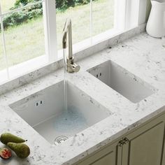 a kitchen sink with two faucets on the counter top next to each other