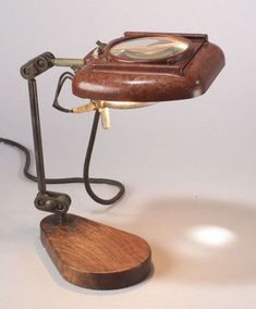 an old fashioned desk lamp with a magnifying glass on it