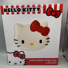 the hello kitty shaped ceramic trinket tray has a red bow on it's head