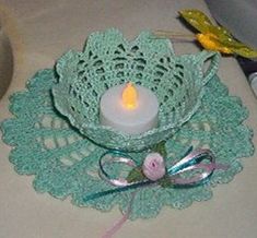 a lit candle is sitting on a doily