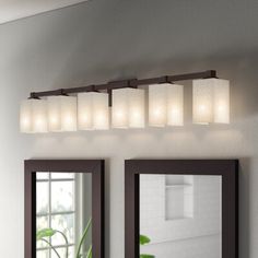 a bathroom vanity with two mirrors and lights