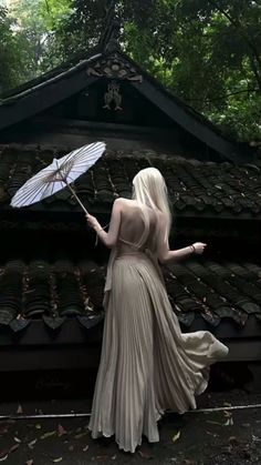 a woman in a long dress holding an umbrella