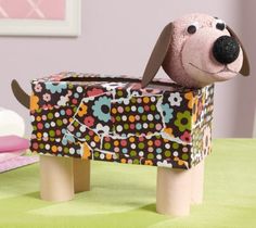 a toy dog sitting on top of a wooden bench in front of a pink wall