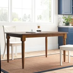 a table and two chairs in a room with blue cupboards on the wall behind it