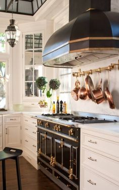 a stove top oven sitting inside of a kitchen next to a table with chairs on it