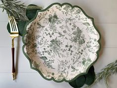 a green and white plate sitting on top of a wooden table next to a fork